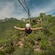 A woman smiling and holding her arms outstretched while riding a zip line head first